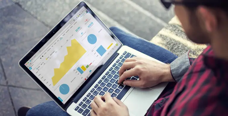 Una persona consulta indicadores y gráficos de gestión comercial en una notebook